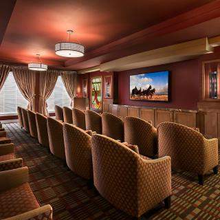 A cozy home theater room with comfortable seating and a large screen.