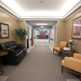 A spacious and well-lit hallway featuring comfortable seating and decorative elements.