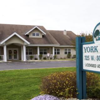 Exterior view of a healthcare facility with a visible sign in the foreground.