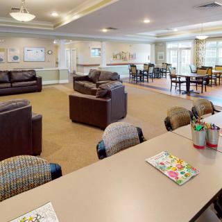 A spacious and well-lit living room with comfortable couches and tables designed for relaxation and social gatherings.