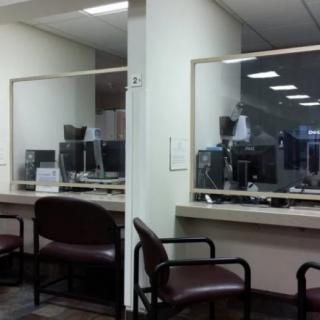 An empty office waiting area with chairs and a glass partition.
