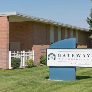 A brick building with a sign reading 'Gateway International School' set in a grassy area.
