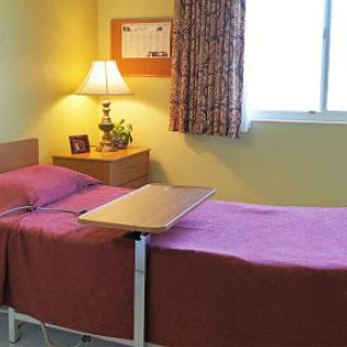 A cozy hospital room featuring two beds and a warm lighting setup.