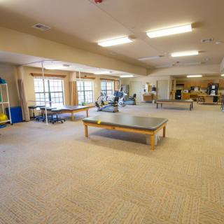 A spacious fitness center with various gym equipment and exercise areas.