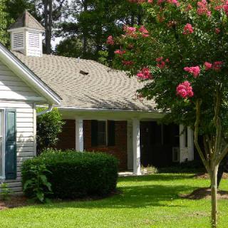 A suburban house with a well-maintained garden and blooming trees.