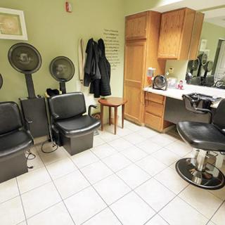 A cozy hair salon with seating, mirrors, and hair drying stations.