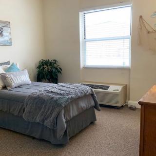 A cozy bedroom with a single bed, a window, and minimalist decor.