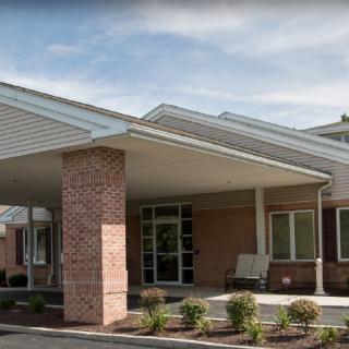 The exterior view of a building entrance with a covered walkway and landscaped surroundings.