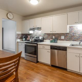 Modern kitchen with stainless steel appliances and hardwood flooring.