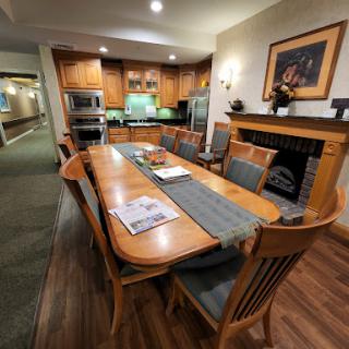 A cozy dining area featuring a wooden table and chairs, integrated with a kitchen space.