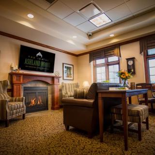 A cozy living room with a fireplace, comfortable furniture, and warm lighting.