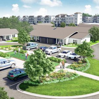 An aerial view of a residential housing complex with landscaped gardens and parking facilities.