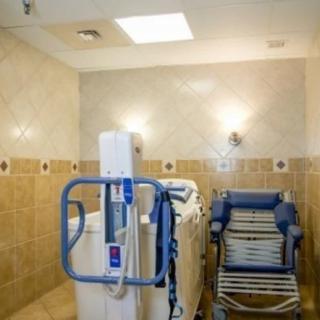 An accessible bathroom equipped with a shower chair and disability lift for easy bathing.