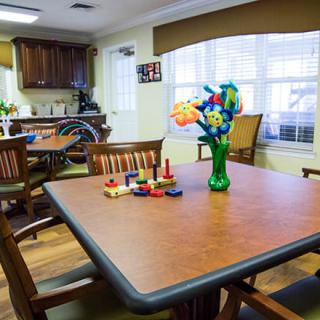 A well-lit dining area featuring a table with colorful flower decorations.