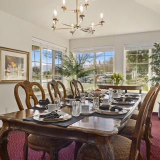 A beautifully set dining room with elegant wooden furniture and a chandelier.