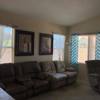 A cozy living room featuring comfortable seating and bright, airy windows.