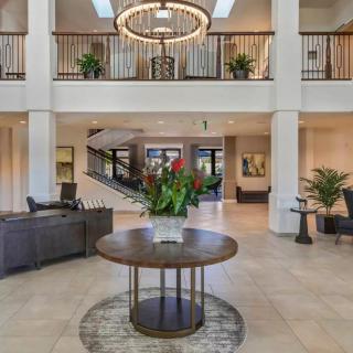 A spacious and elegantly decorated lobby with modern furnishings and a large chandelier.