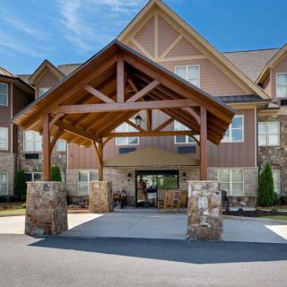 Entrance of a modern building with a wooden and stone covered walkway.