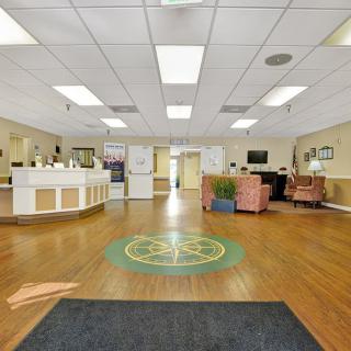 A spacious reception area with a check-in desk and seating.