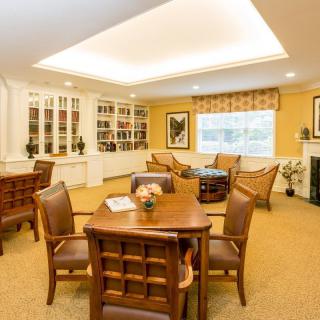 A cozy living room with a dining area, featuring elegant furniture and a warm fireplace.