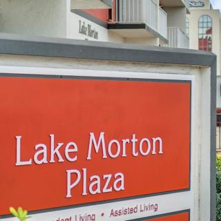 Sign for Lake Morton Plaza in front of residential buildings.