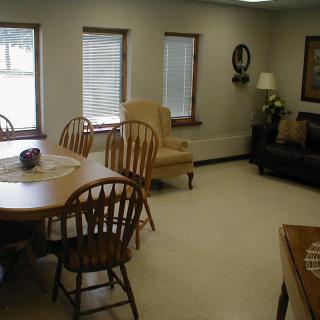 A cozy living room with wooden furniture and multiple windows.