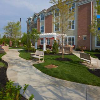A well-maintained apartment building with landscaped grounds and benches.