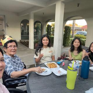 A family enjoying a meal together outdoors.