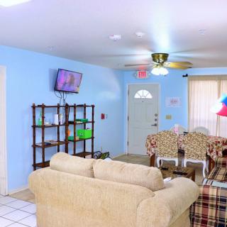 A cozy living room with blue walls, featuring a sofa, television, and other furniture.