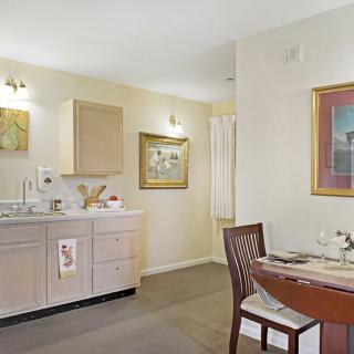 A modern kitchen and dining area with light-colored cabinets and elegant decor.