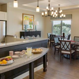 A cozy dining area with a breakfast buffet setup and elegant chandeliers.