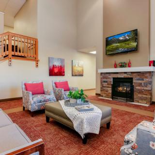A modern living room with a cozy fireplace, stylish furniture, and decorative artwork.