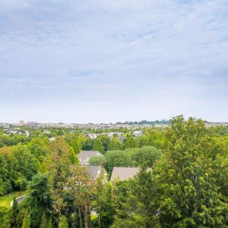 A scenic view of a suburban area surrounded by lush greenery under a clear sky.