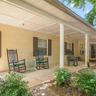 A cozy covered porch with rocking chairs and well-maintained landscaping.