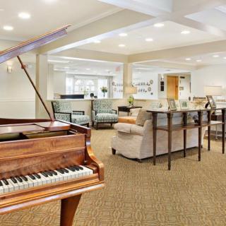 A spacious living room featuring a grand piano and elegant furniture.