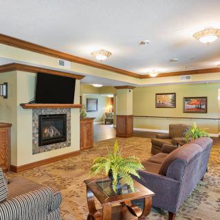 A cozy living room with a fireplace and television, featuring comfortable seating and elegant decor.