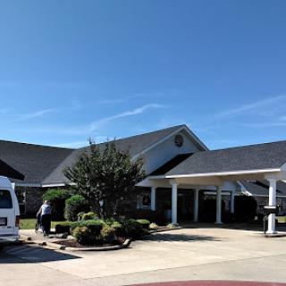 A sunny day at a well-maintained healthcare facility surrounded by greenery.