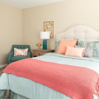A cozy and stylish bedroom with a colorful bedspread and decorative pillows.
