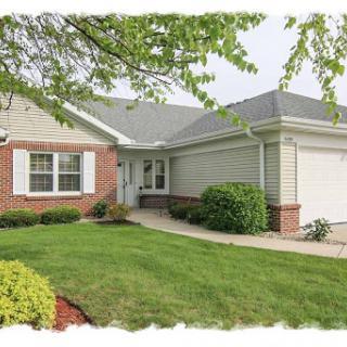 A charming single-story house with a well-maintained lawn and attached garage.