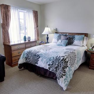 A cozy bedroom with a neatly made bed, soft lighting, and elegant decor.
