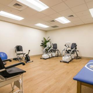 A well-equipped room for physical therapy and rehabilitation with exercise machines and seating.