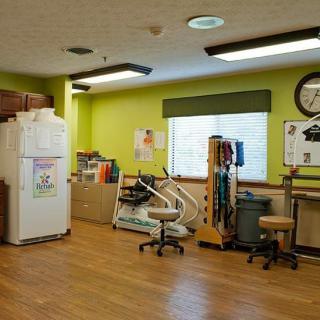 A medical office with chairs, equipment, and light green walls.