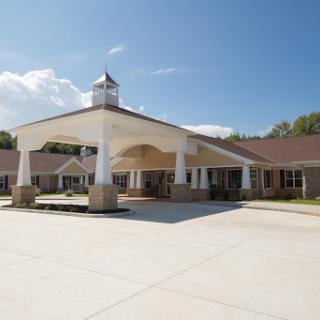 A modern building entrance with a covered porch under a clear blue sky.