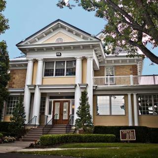 A historic building with classical columns and manicured landscaping.