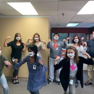 A fun day at the office as the team showcases their playful spirit with masks and poses.