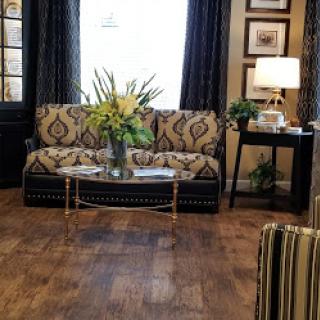 A beautifully designed living room featuring a patterned sofa, floral centerpiece, and elegant decor.