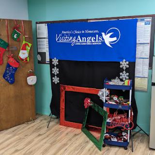 A festive setup featuring a Living Angels backdrop with holiday decorations, perfect for events and activities.