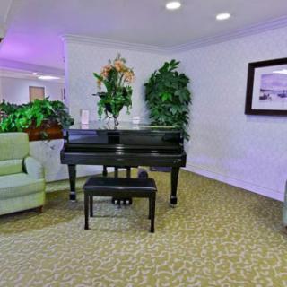A stylish living room featuring a grand piano and elegant decor.