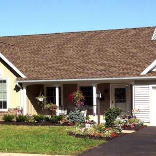 A single-story house with a well-maintained garden and a driveway.