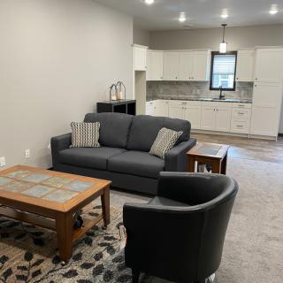 A modern open floor plan living room with comfortable seating and a view of the kitchen area.